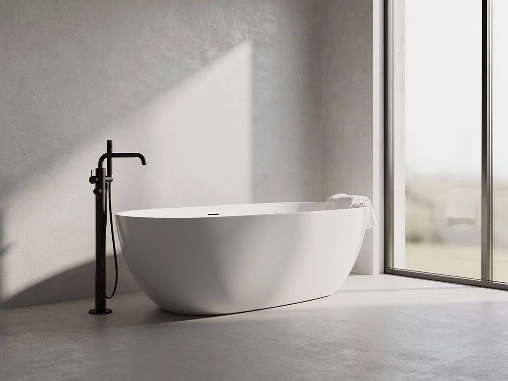 Baignoire îlot ovale près d'une fenêtre avec mitigeur noir mat sur sol béton ciré